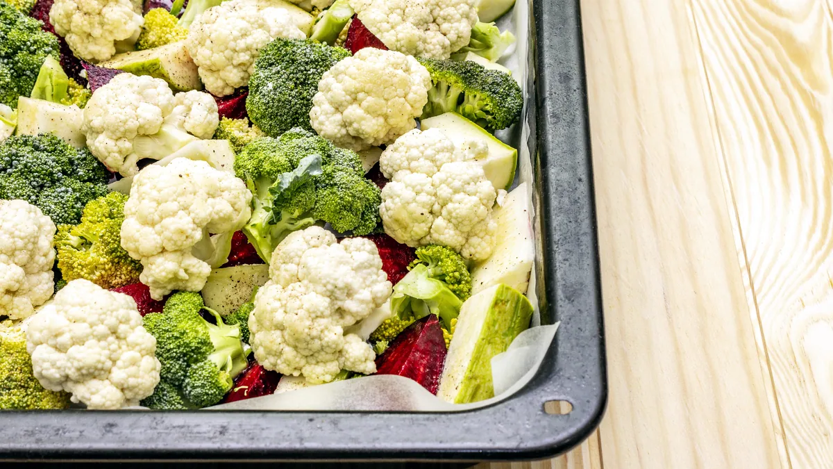 Roasted broccoli florets with charred edges spread across a sheet pan.