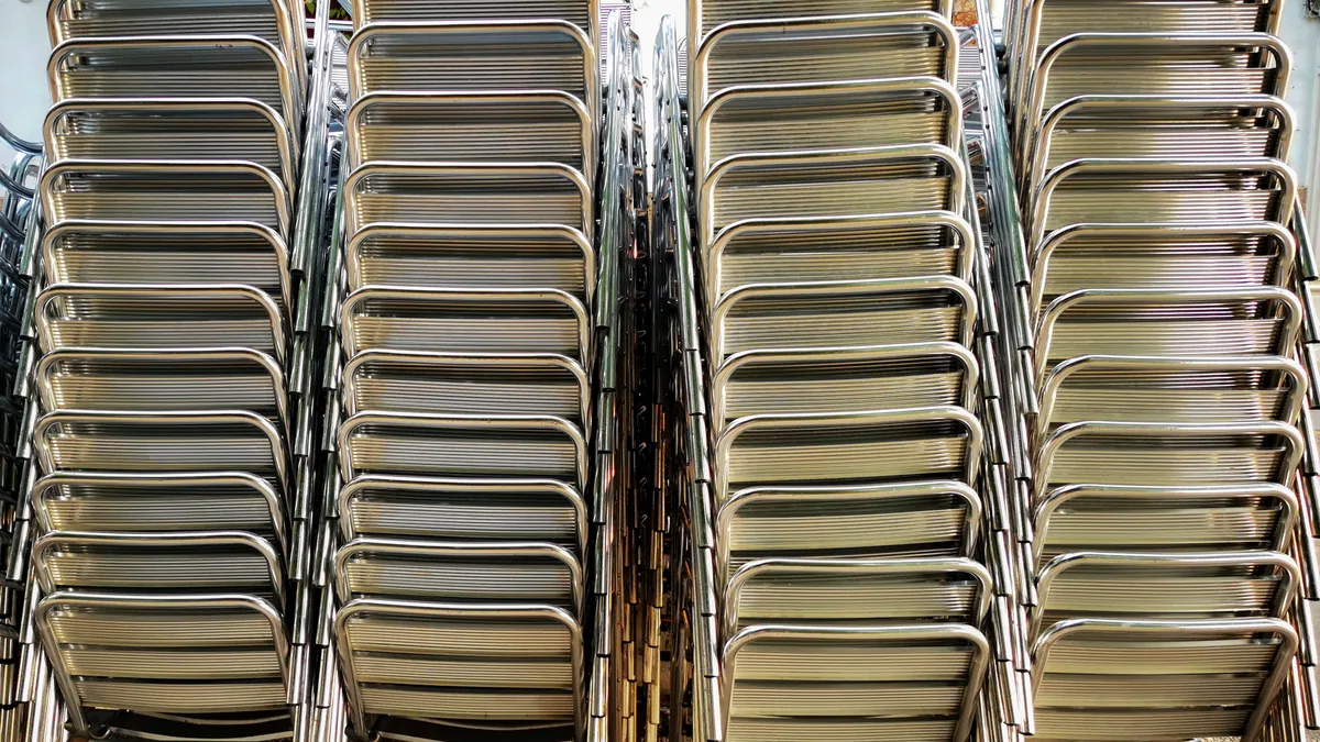Stacked catering equipment, trays and pans, loaded inside the back of a van.