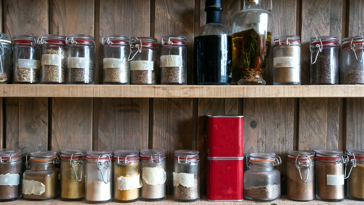 A larder shelf packed with jars and tins of wild game provisions.