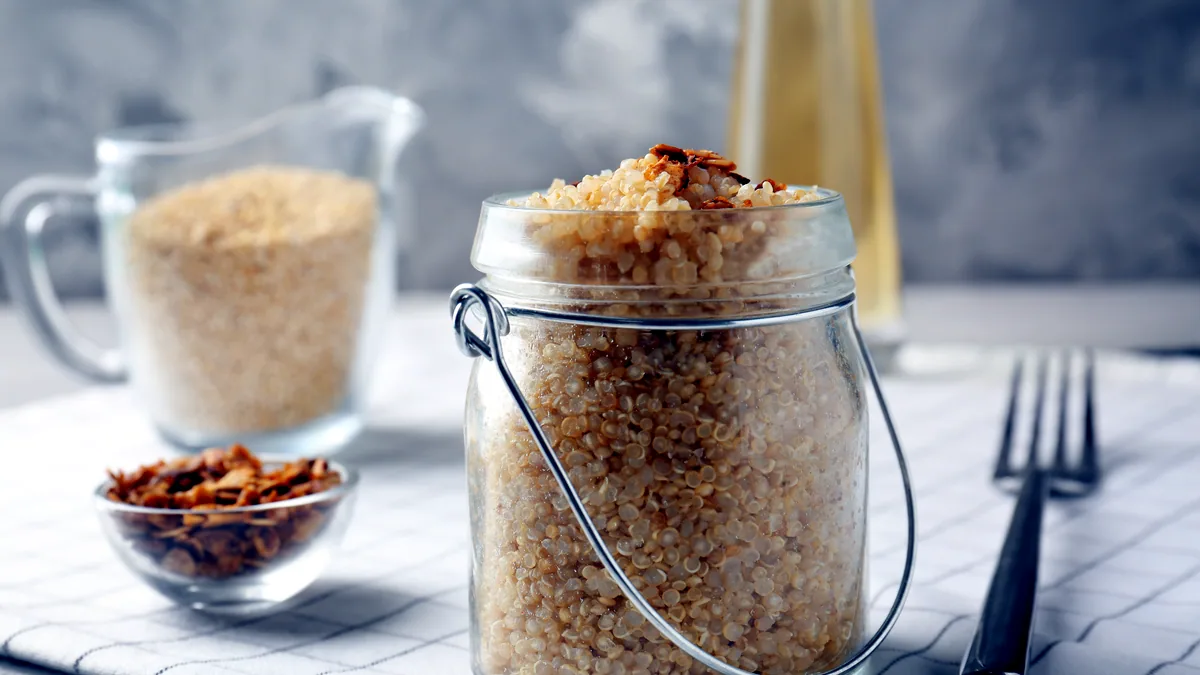 Light and fluffy cooked quinoa served in a clear glass bowl.